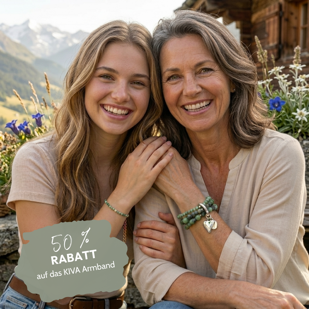 Eine junge Frau mit langen blonden Haaren und eine ältere Frau mit grauen Haaren lächeln in die Kamera. Beide tragen grüne Perlenarmbänder. Im Hintergrund sind Berge, ein Holzhaus, blaue Enziane und weisse Edelweißblumen zu sehen.