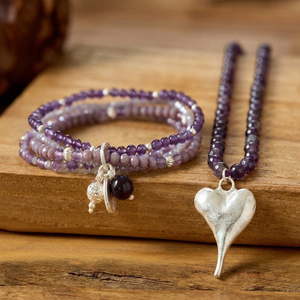 Handgefertigtes Schmuck-Set aus violetten Amethyst-Perlen mit silberfarbenem Herzanhänger, bestehend aus Halskette und Armband.