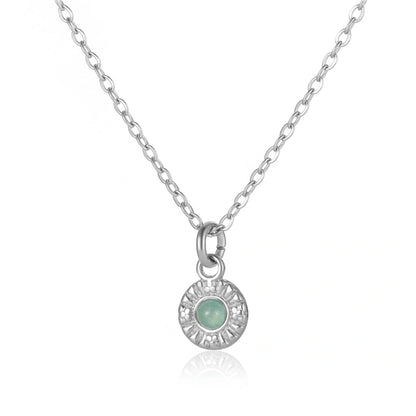 Elegante Silberhalskette mit einem runden Anhänger, der einen hellgrünen Stein im Zentrum trägt. Das polierte Silber des Anhängers zeigt ein filigranes, sonnenförmiges Muster, perfekt für stilvollen Schmuck.