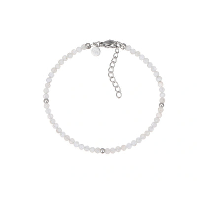 Filigranes Perlenarmband aus schimmernden, facettierten weißen Naturstein-Perlen, akzentuiert mit drei glänzenden Silberkugeln. Es verfügt über einen eleganten silbernen Karabinerverschluss und eine praktische Verlängerungskette, ideal für Damen.