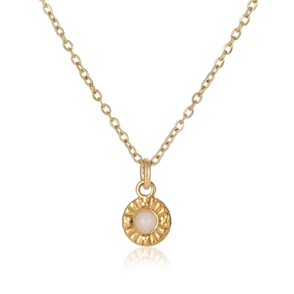 Elegante Goldkette mit filigranem Rundanhänger. Ein schimmernder, milchig-weißer Edelstein ist mittig platziert und von kunstvollen floralen Prägungen umgeben, perfekt für zeitlose Eleganz.